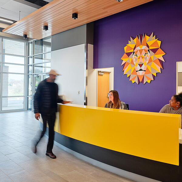 People Engage in Conversation in a Modern Office Lobby with Colorful Decor
