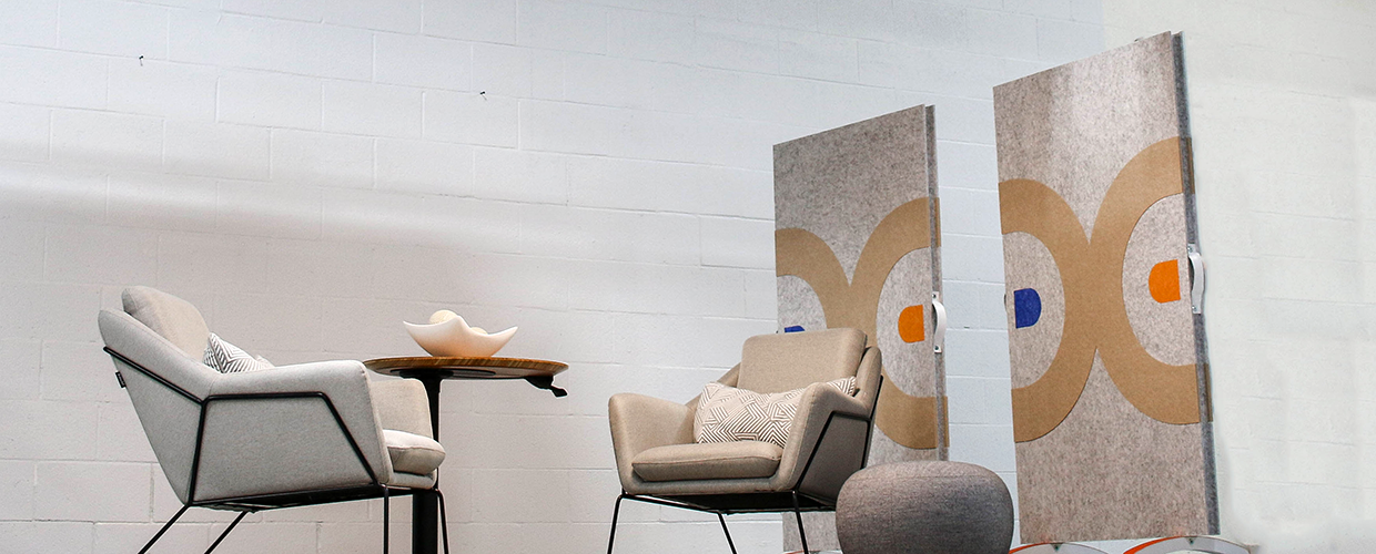 Modern Living Space Featuring Two Chairs, a Table, and Artistic Panels on a White Brick Wall