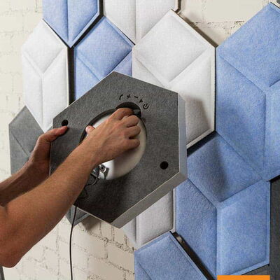 Person Installing Gray and Blue Acoustic Panels on a Wall