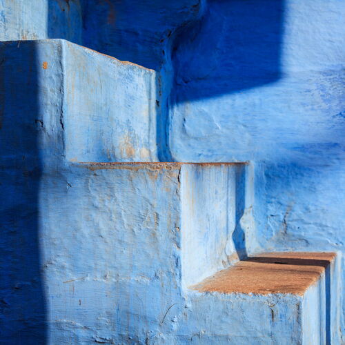 Vibrant Blue Stairs and Walls with Shadows Under Sunlight