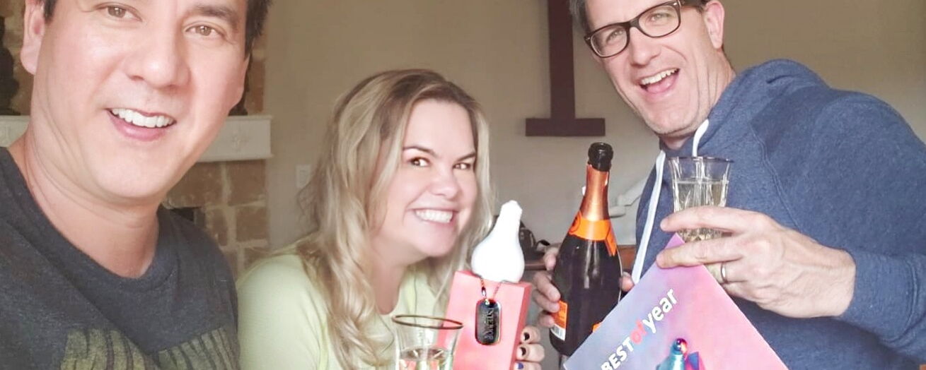 Three People Celebrating with Champagne and Smiling