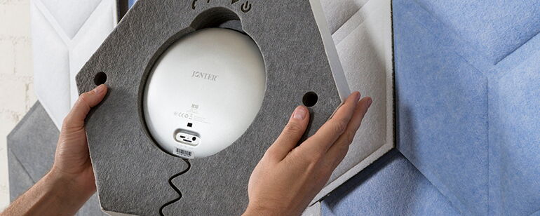 Person Installing a Hexagonal Sound Absorbing Panel on a Wall