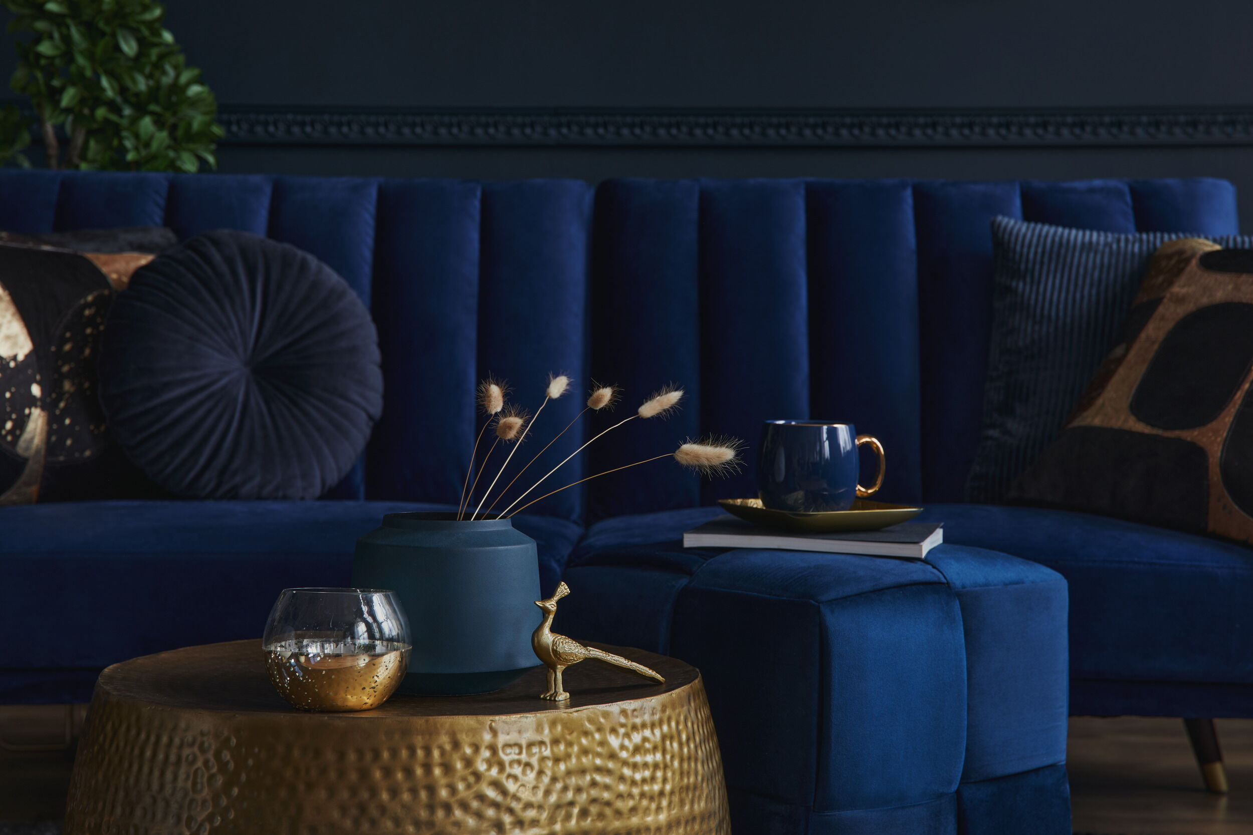Elegant Blue Velvet Sofa with Gold and Navy Blue Accents in a Stylish Living Room