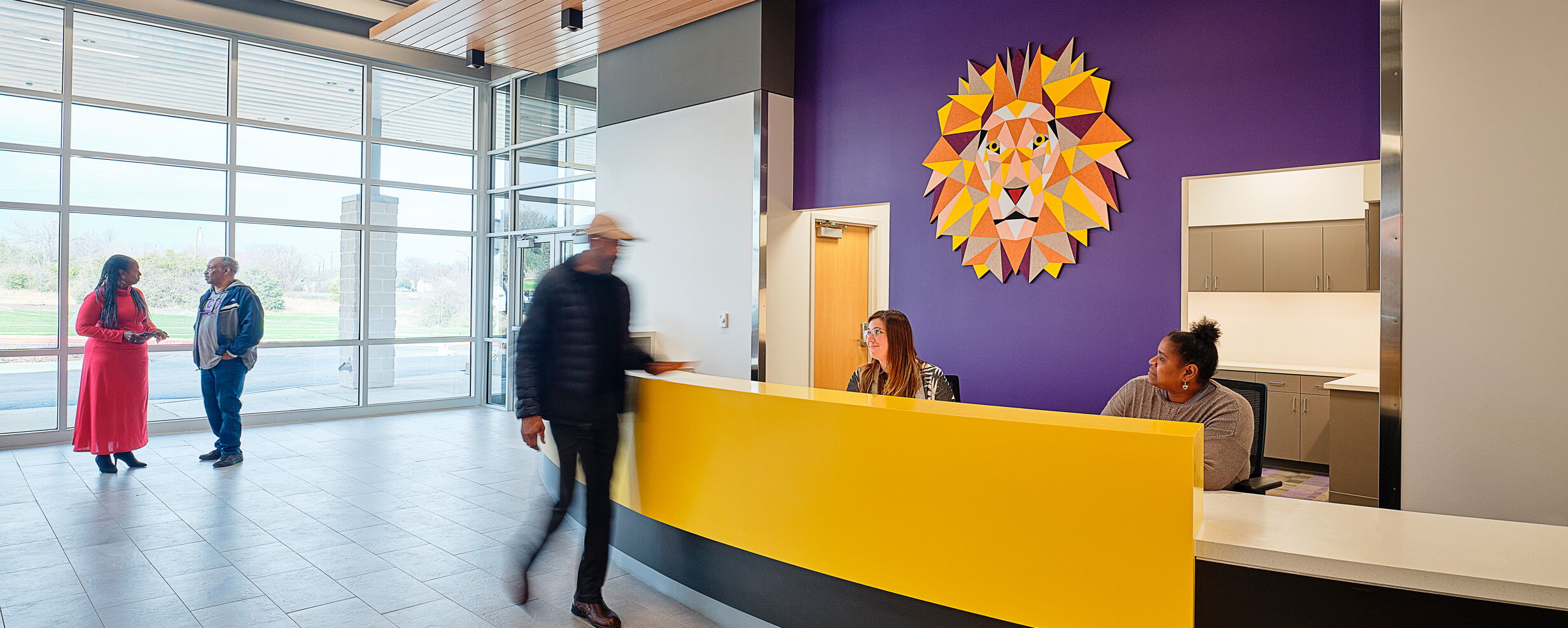 People Engage in Conversation in a Vibrant Modern Office Lobby with Artistic Decor