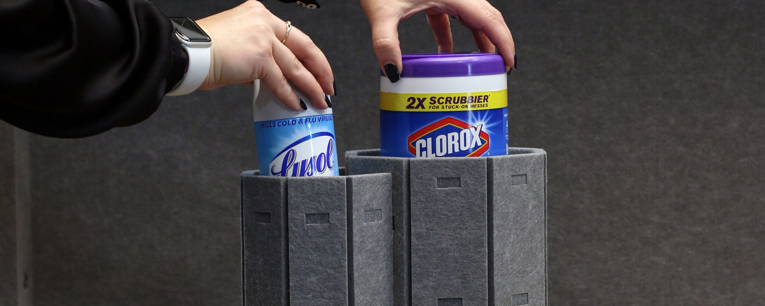 Hands Placing Disinfectant Wipes on a Modern Gray Structure
